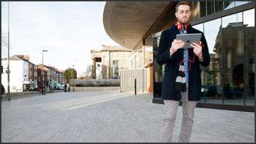Illustration 560x315 xavier laurent blavatnik lecture capture A male student looks at a tablet computer outside the Blavatnik building, Oxford